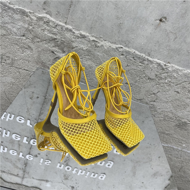 Zapatos de tacón alto de malla con punta cuadrada y cordones que se atan en los tobillos.